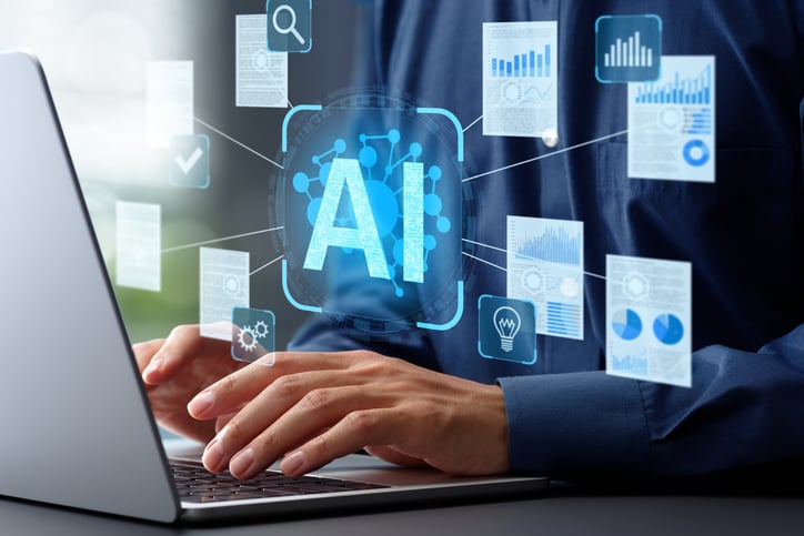 Person using laptop with AI and data analytics graphics overlay, symbolizing artificial intelligence productivity tools.