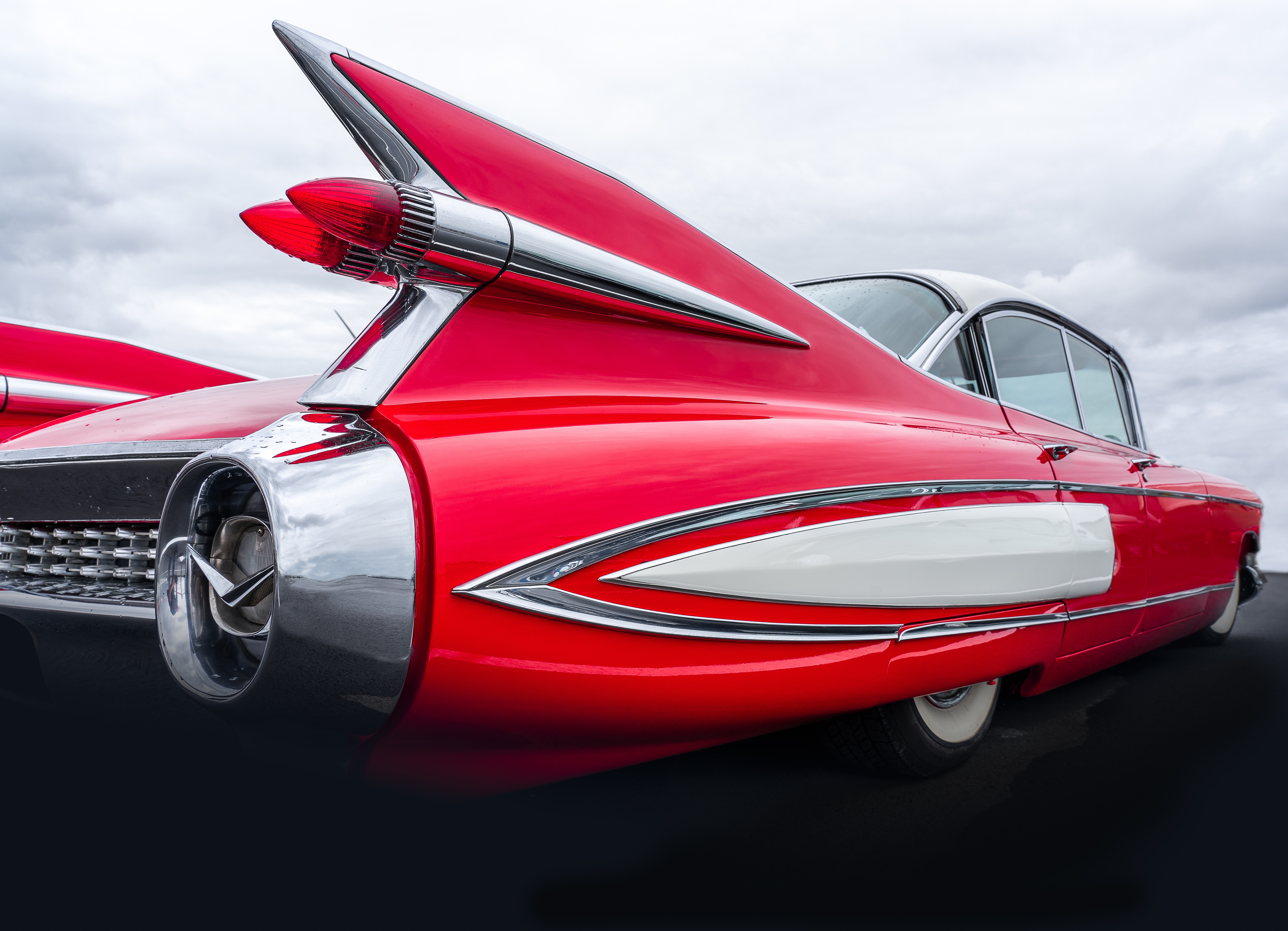 closeup-shot-back-part-red-car-sky-full-clouds